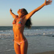 Girl at the beach stretching out her hands